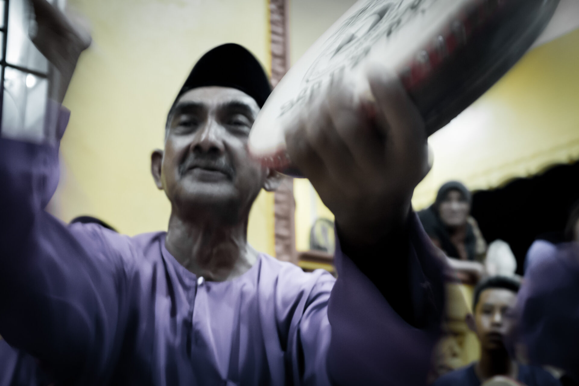 A man in cap performing Kompang Jidor artform