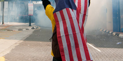 Man covering head with Malaysian flag during Bersih rally