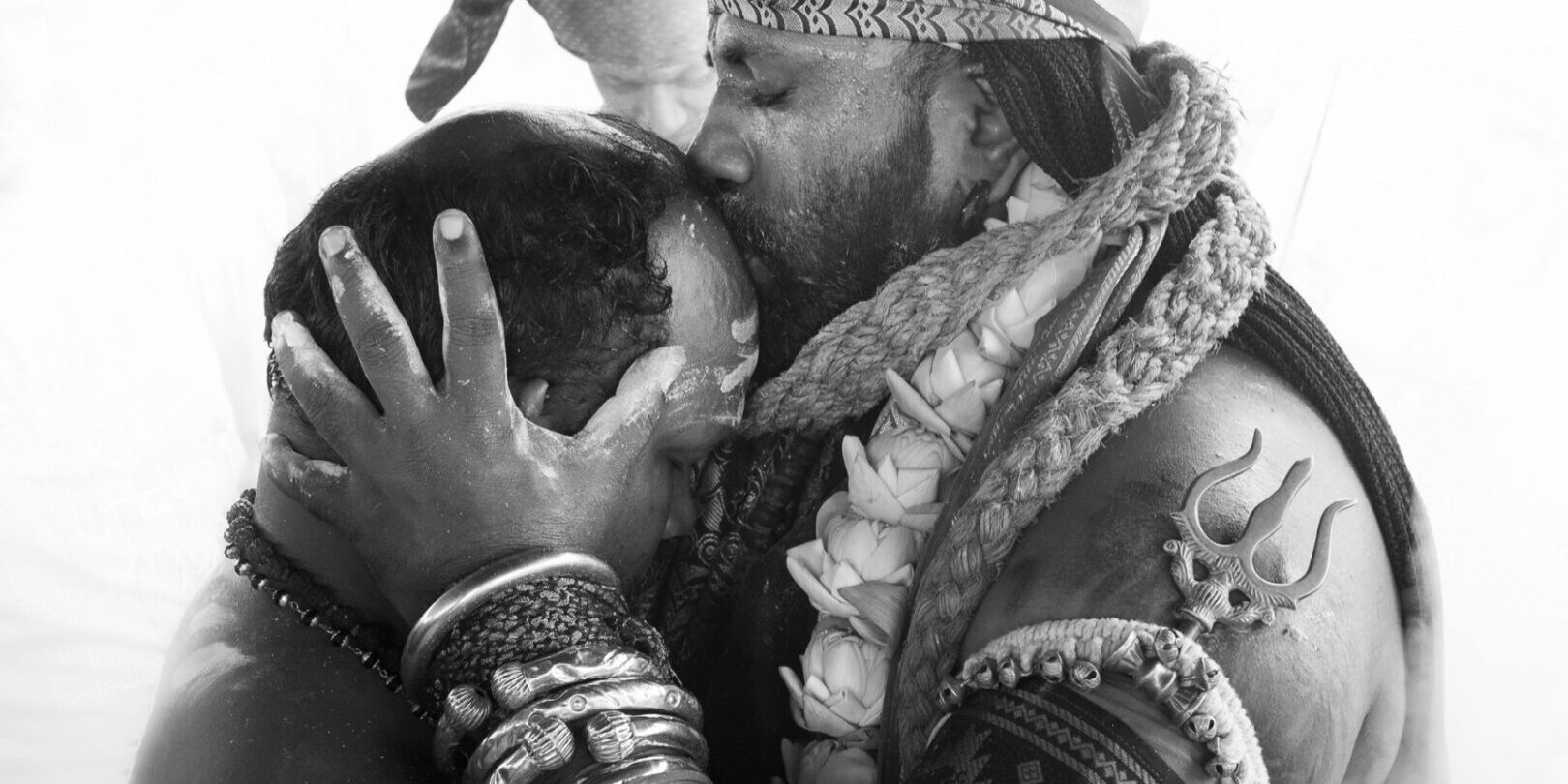 A hindu religious person kissing another person on forehead